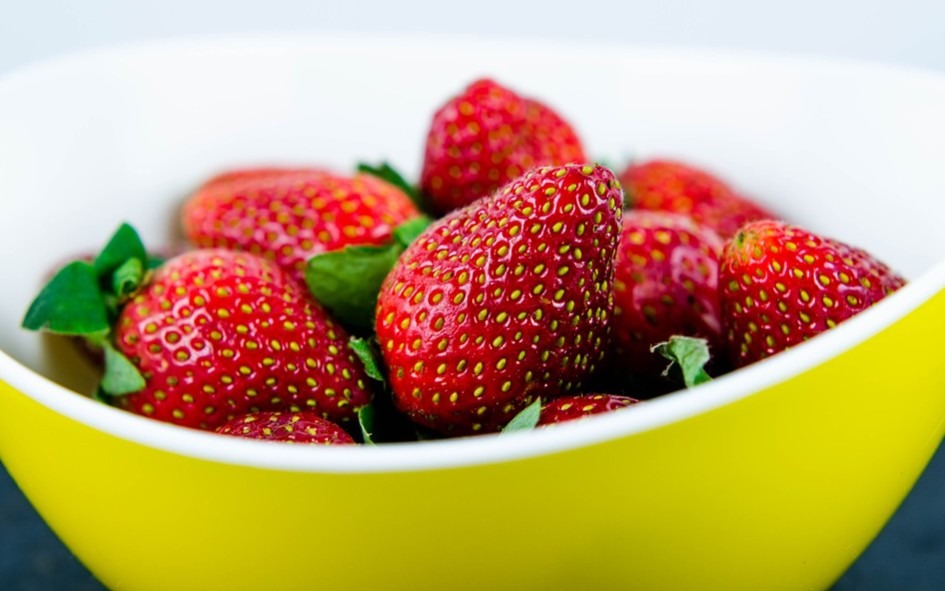 a yellow bowl filled with strawberries