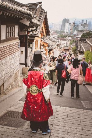 man wearing a Hanbok while walking along the street