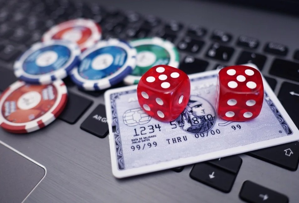 poker chips, dice, and a credit card on a laptop