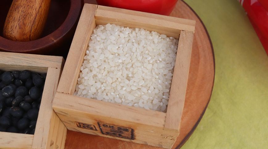 box, rice grains, mortar ad pestle, black beans