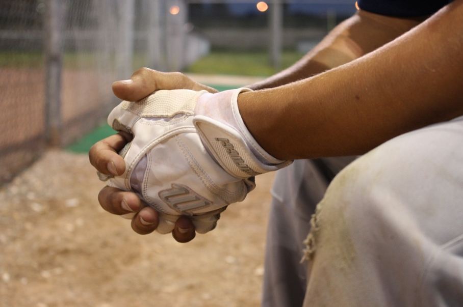 hands of a baseball player, gloved hand, white pants, baseball field