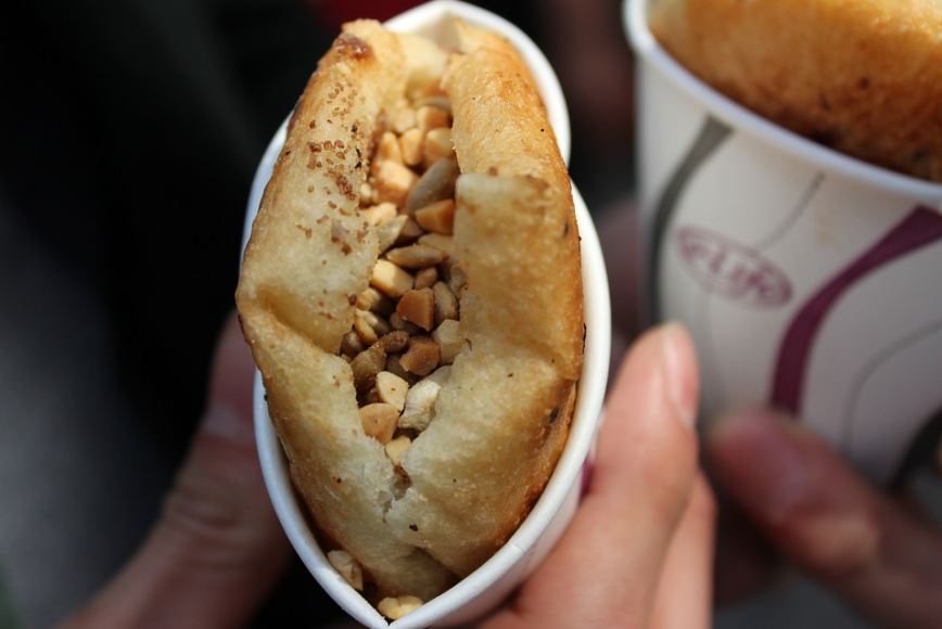 hotteok with chopped nuts in a cup, fingers