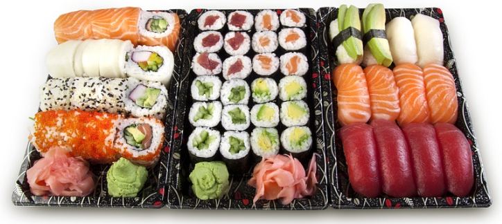 three trays of sushi rolls
