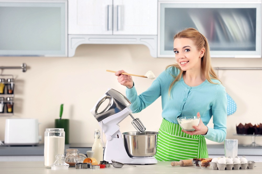 Young woman adding flour to a food processor to male a dough