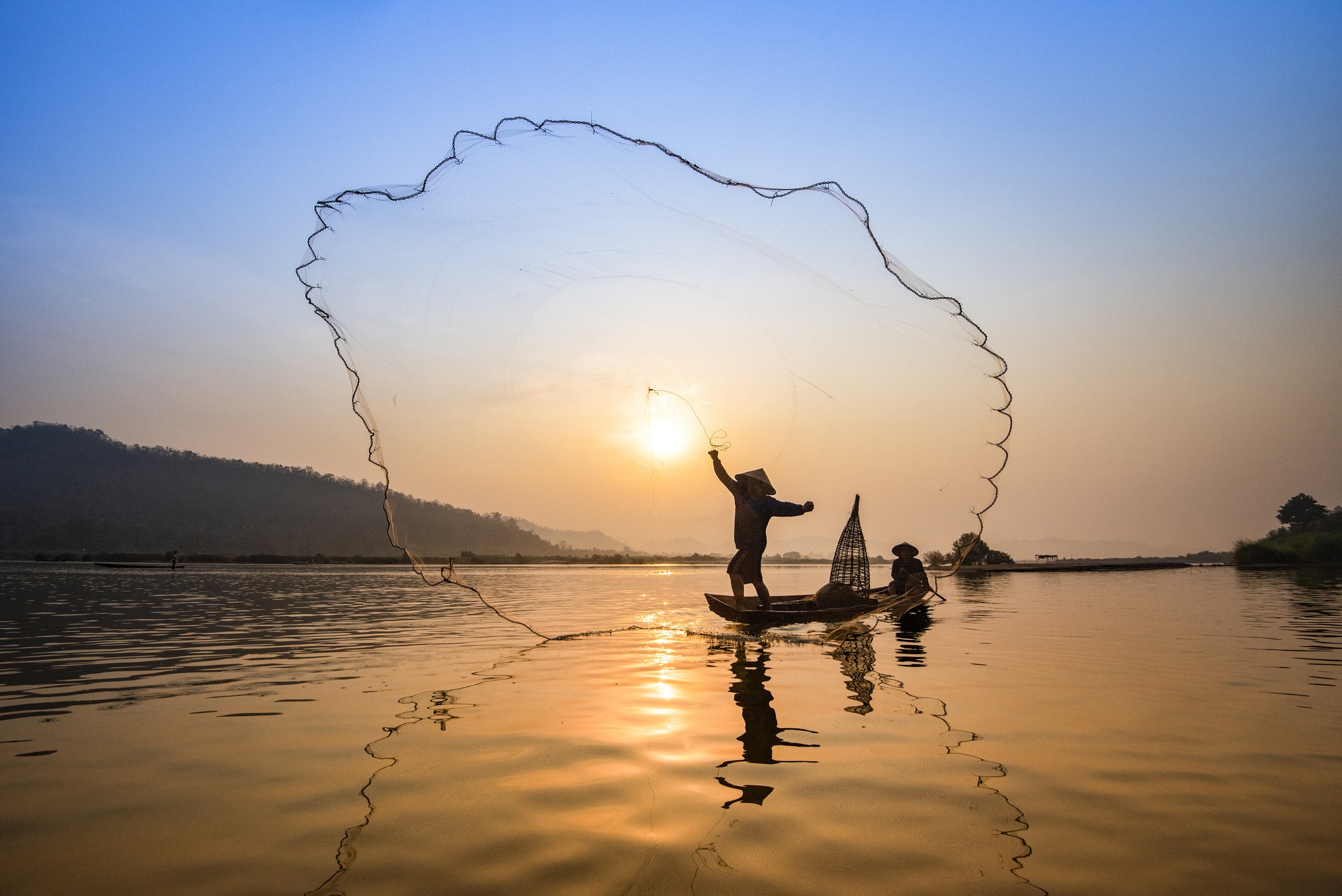 Asia-fisherman-net-using-on-wooden-boat-casting-net-sunset