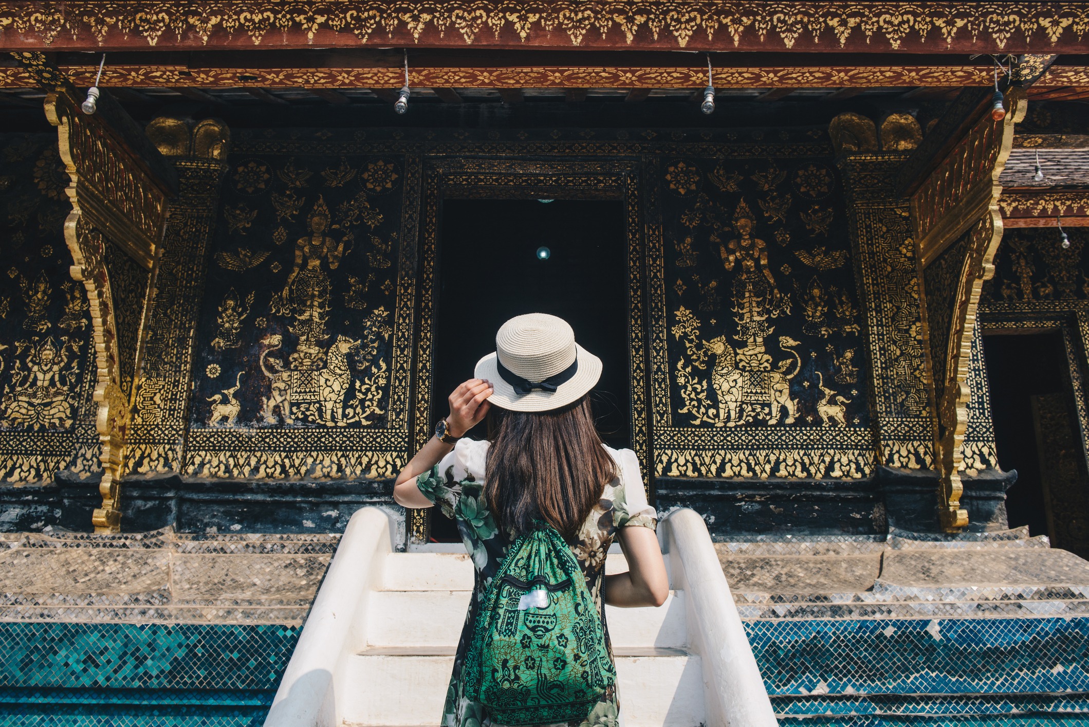 Back-view-of woman-tourist-visiting-Wat-Xieng-Thong 