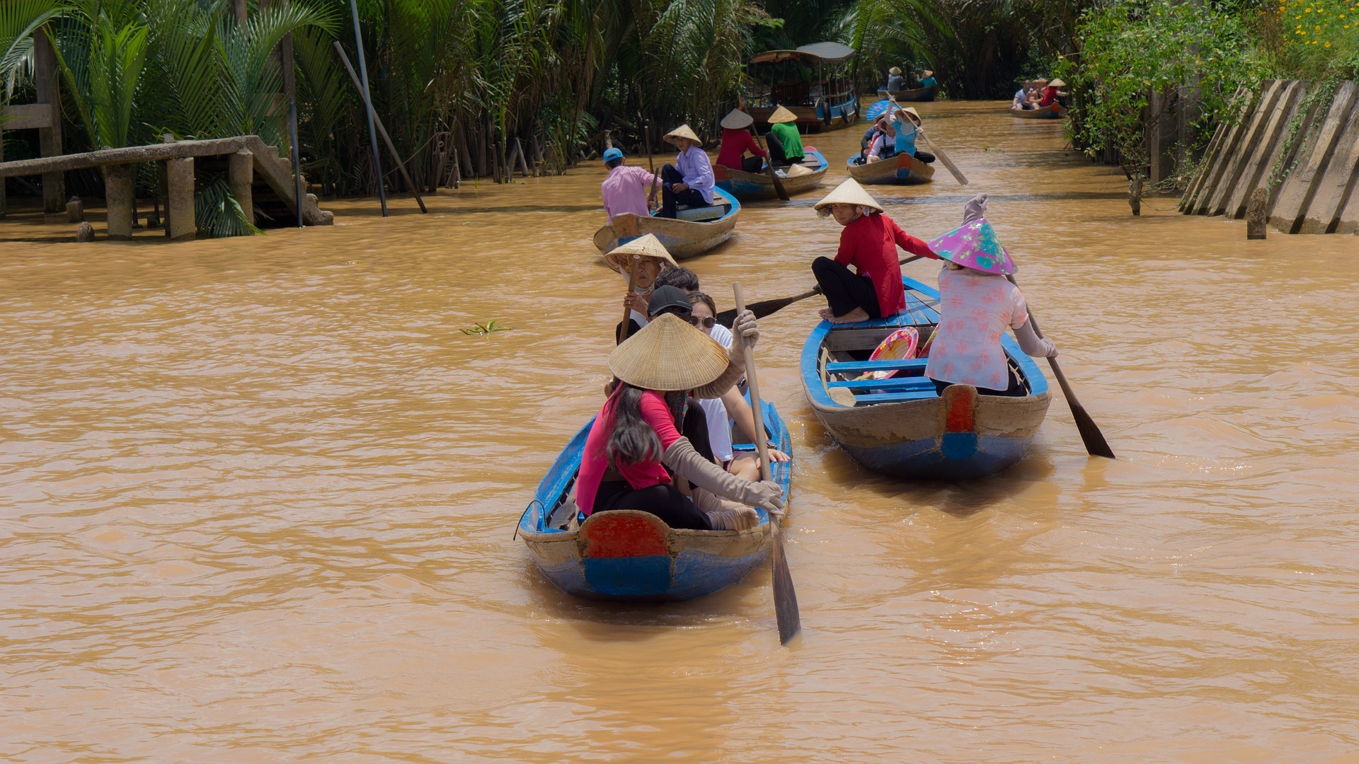 several-groups-of-people-cruising-through-the-Mekong-River-on-a-blue-boat