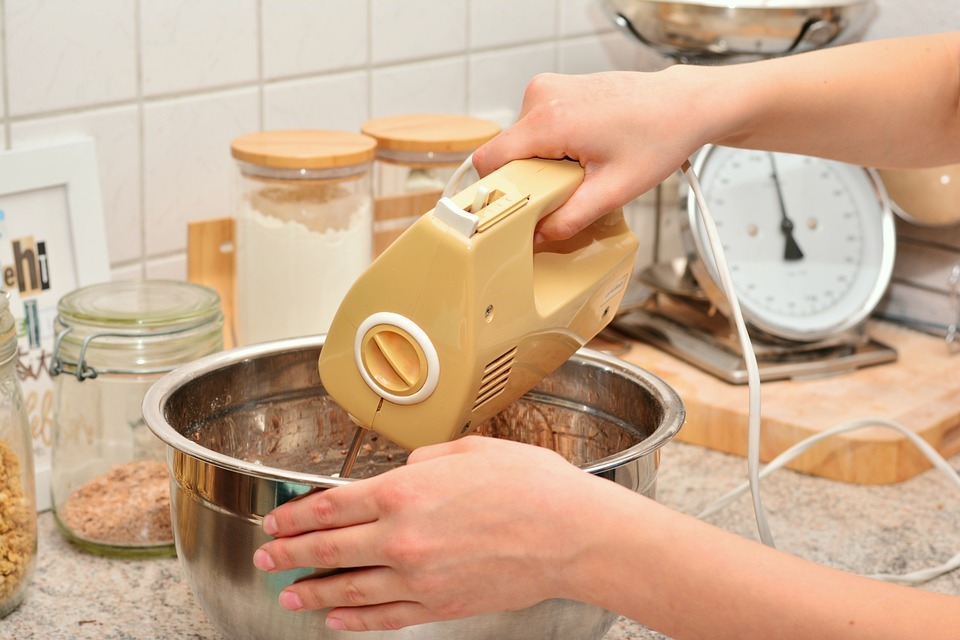 Hand-using-a-hand-mixer-to-stir-dough