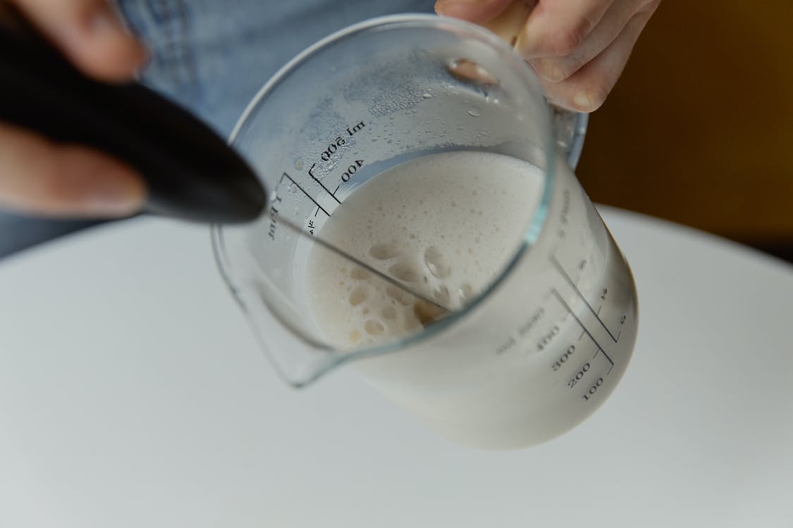 a-person-holding-glass-measuring-cup